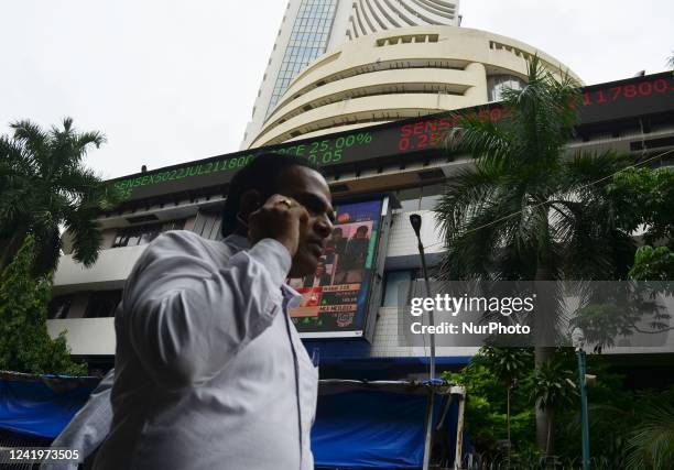 Man on phone walks past Bombay Stock Exchange office in Mumbai, India, 18 July, 2022. The S&amp;P BSE Sensex jumped 760 points to end at 54,521 level...