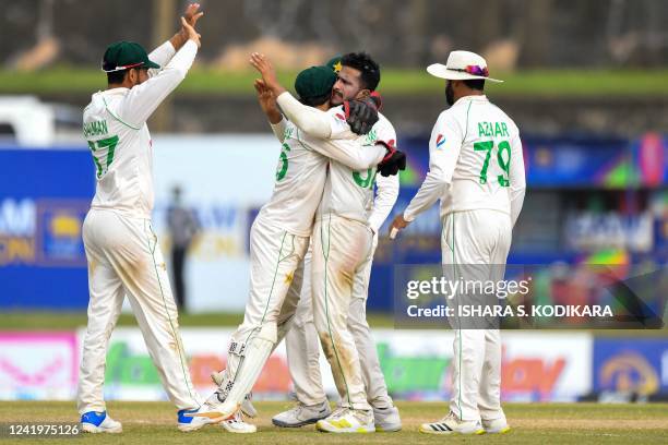Pakistans Hasan Ali celebrates with teammates after taking the wicket of Sri Lanka's Maheesh Theekshana during the third day of play of the first...