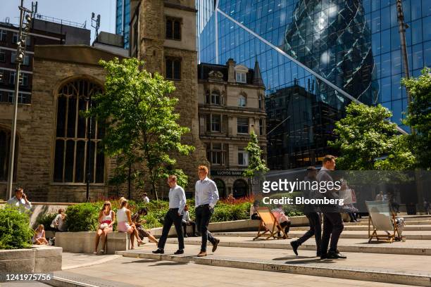 City workers pass through a square at lunchtime during a heatwave in London, UK, on Monday, July 18, 2022. Extreme heat could lead to power outages,...