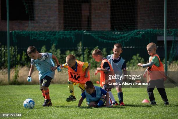 Boys attend a football training session organized by Hostomel village council and led by football coach Serhii Ivankiv on July 18, 2022 in Hostomel,...