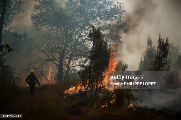 Firefighter takes position at a forest fire near Louchats, some 35kms from Landiras in Gironde, southwestern France on July 18, 2022. - The intense...