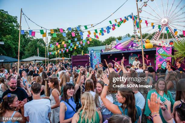 People are seen dancing and raising their hands in the air during a concert. The Vierdaagsefeesten is the largest freely accessible event in the...