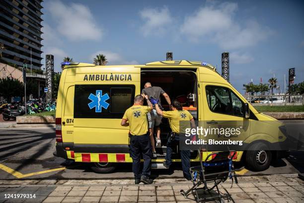 Paramedics help a patient into an ambulance during a heat wave in Barcelona, Spain, on Monday, July 18, 2022. The heat wave killed 360 people dead in...