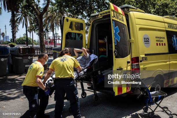 Paramedics help a patient into an ambulance during a heat wave in Barcelona, Spain, on Monday, July 18, 2022. The heat wave killed 360 people dead in...