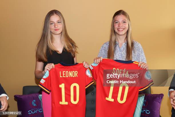 In this handout image provided by the Spanish Royal Household, Princess Leonor of Spain and Princess Sofía of Spain hold football shirts at the UEFA...