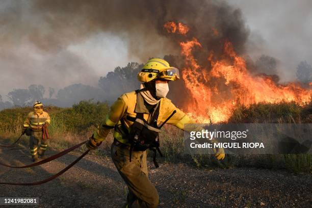 Firefighters try to extinguish a wildfire next to the village of Tabara, near Zamora, northern Spain, on July 18, 2022. - Emergency services battled...