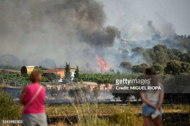 People look at smoke rising from the vineyards in Pumarejo, near Zamora, northwest Spain, on July 18, 2022. - Emergency services battled several...