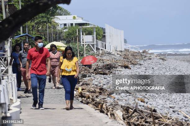 Tourist walk by a beach on July 18, 2022 in La Libertad, El Salvador. According to El Salvador's Ministry of Health more than 11 million vaccine...