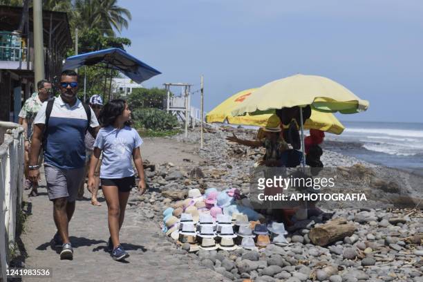 Tourist walk by a beach on July 18, 2022 in La Libertad, El Salvador. According to El Salvador's Ministry of Health more than 11 million vaccine...