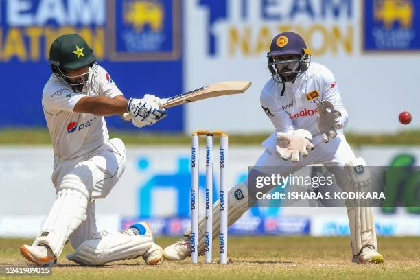 Pakistan's Abdullah Shafique plays a shot as Sri Lanka's wicketkeeper Niroshan Dickwella watches during the fourth day of play of the first cricket...