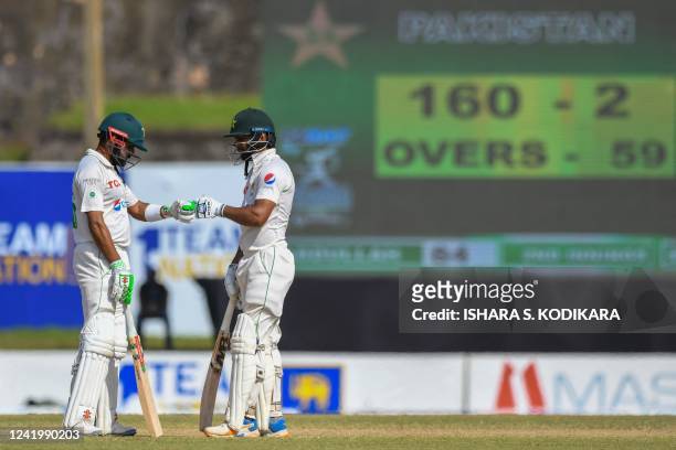 Pakistans Babar Azam and Abdullah Shafique gesture during the fourth day of first cricket Test match between Sri Lanka and Pakistan at the Galle...