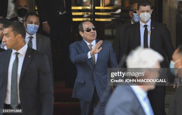 Egypt's President Abdel Fattah al-Sisi waves as he gets out of his hotel in Berlin to leave Germany, on July 19, 2022 after attending the 13th...