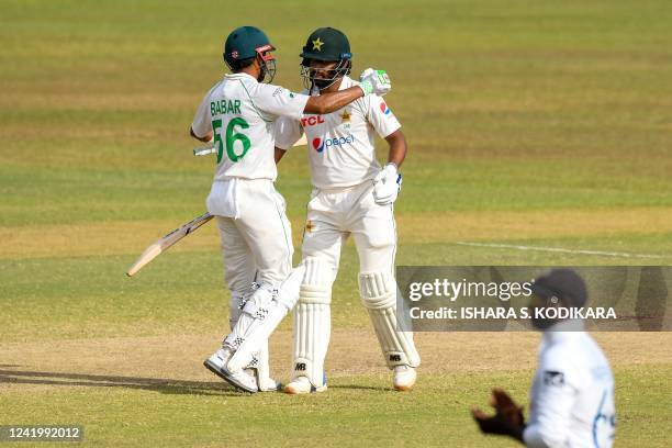 Pakistans Abdullah Shafique is congratulated by his captain Babar Azam after he scored a century during the fourth day of the first cricket Test...