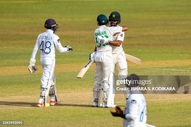 Pakistans Abdullah Shafique is congratulated by his captain Babar Azam after he scored a century during the fourth day of the first cricket Test...