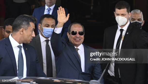 Egypt's President Abdel Fattah al-Sisi waves as he gets out of his hotel in Berlin to leave Germany, on July 19, 2022 after attending the 13th...