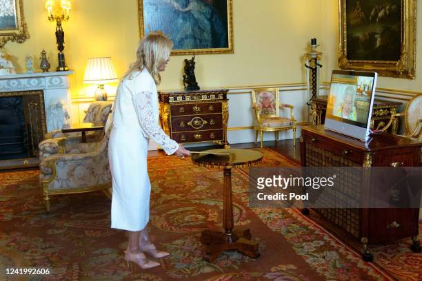 Queen Elizabeth II, in residence at Windsor Castle, appears on a screen via videolink, during a virtual audience to receive the US Ambassador, Jane...