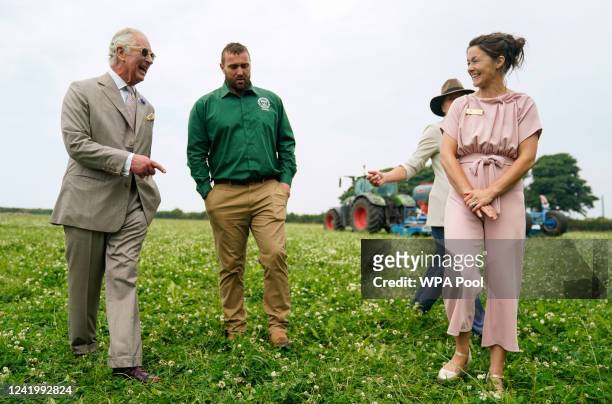Prince Charles, Prince of Wales chats with Matt Smith and his wife Pip Smith as they walk through herbal leys as he attends the Innovative Farmers...