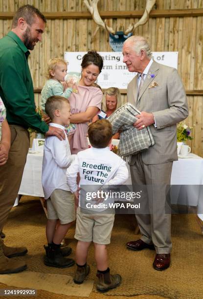 Prince Charles, Prince of Wales is given a gift by Dusty and George Smith, sons of Matt and Pip Smith, as he attends the Innovative Farmers 10th...