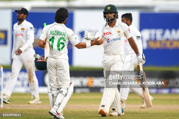 Pakistan's Abdullah Shafique and Mohammad Rizwan walk back to the pavilion at the end of the fourth day play of the first cricket Test match between...