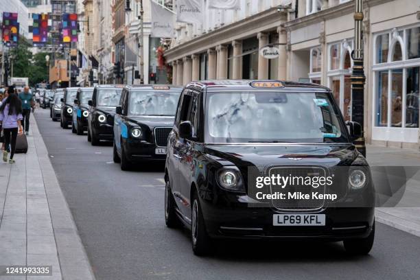 Electric taxis form a line along Bond Street on 12th July 2022 in London, United Kingdom. Bond Street is one of the principal streets in the West End...