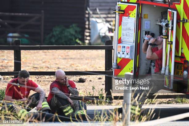 Firefighters react after attending to fires that had broken out in the hot weather on July 19, 2022 in Wennington, England. A series of grass fires...
