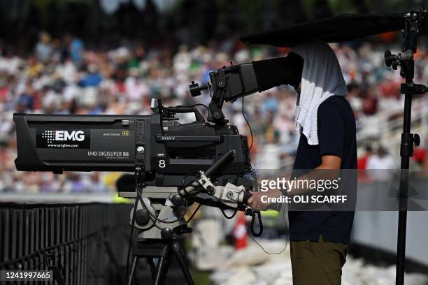 Cameraman protects himself from the sun and the heat with a towel during the first One Day International cricket match between England and South...