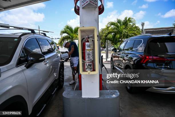 Person pumps gas into his car at a gas station in Miami, Florida, on July 19, 2022. US gasoline prices have fallen from historic highs earlier in the...