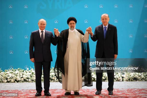 Russian President Vladimir Putin, Iranian President Ebrahim Raisi and Turkish President Recep Tayyip Erdogan pose for a photo before a trilateral...