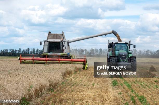 Farmers harvest a wheat field in the Ukrainian Kharkiv region on July 19 amid Russian invasion of Ukraine. Russia and Ukraine on July 22, 2022 signed...