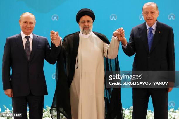 Russian President Vladimir Putin, Iranian President Ebrahim Raisi and Turkish President Recep Tayyip Erdogan pose for a photo before a trilateral...