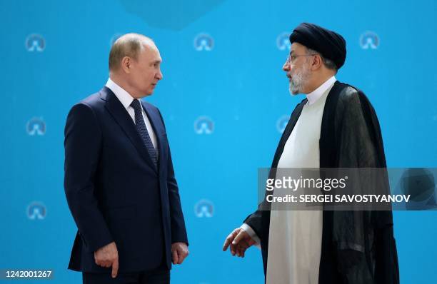 Iranian President Ebrahim Raisi and Russian President Vladimir Putin speak to each other before a trilateral meeting on Syria with Turkish President...