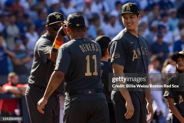 Rafael Devers of the Boston Red Sox high fives manager Dusty Baker of the Houston Astros and Shohei Ohtani of the Los Angeles Angels of Anaheim...