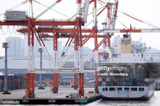 The OOCL Dalian container ship, operated by Orient Overseas Container Line Ltd., loaded with containers, berthed next to gantry cranes at a shipping...