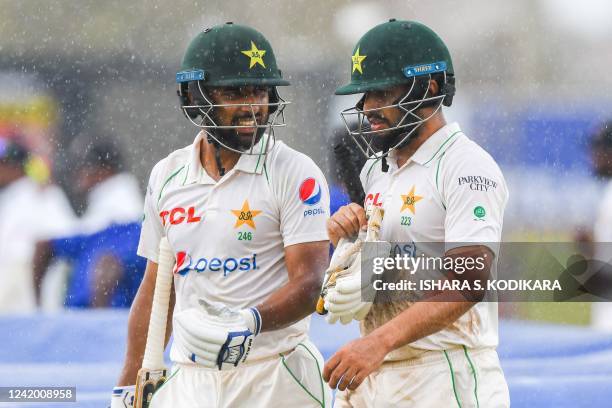 Pakistans Abdullah Shafique and Mohammad while walk back to the pavilion after rain stopped play during the final day of the first cricket Test match...