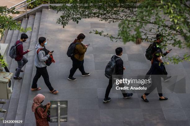 People use their smartphones on the street in Jakarta, Indonesia on July 20, 2022. The country urged the tech companies on Monday to register under...