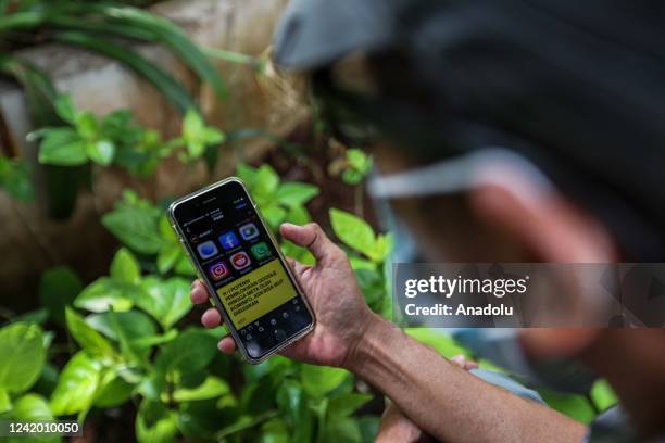 People use their smartphones on the street in Jakarta, Indonesia on July 20, 2022. The country urged the tech companies on Monday to register under...
