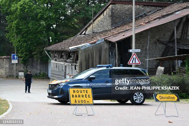 French gendarme car blocks the road leading to the house in which a man suspected of having shot five people, barricaded himself" before he was shot...