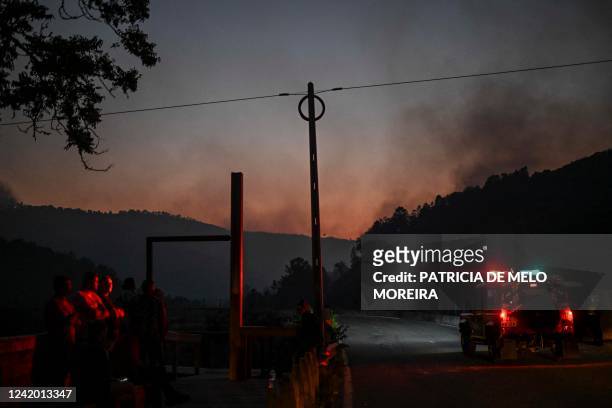 Residents stand watching the progression of a wildfire at Murca in Vila Real, north of Portugal, on July 19, 2022.