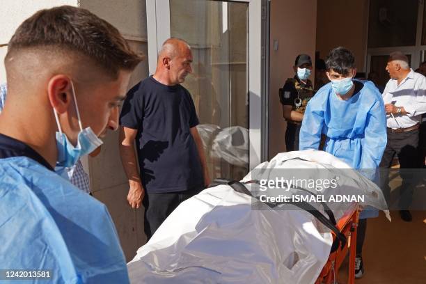 Medics transport the body of a victim following Turkish shelling in the city of Zakho in the north of Iraq's autonomous Kurdish region on July 20,...
