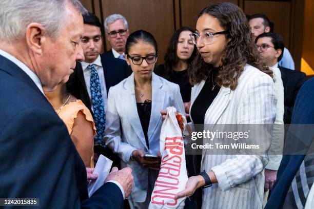 Rachel Jacoby gives a piece of a memorial for victims of the Highland Park, Ill., shooting that readsHPSTRONG, to Chairman Sen. Richard Durbin,...
