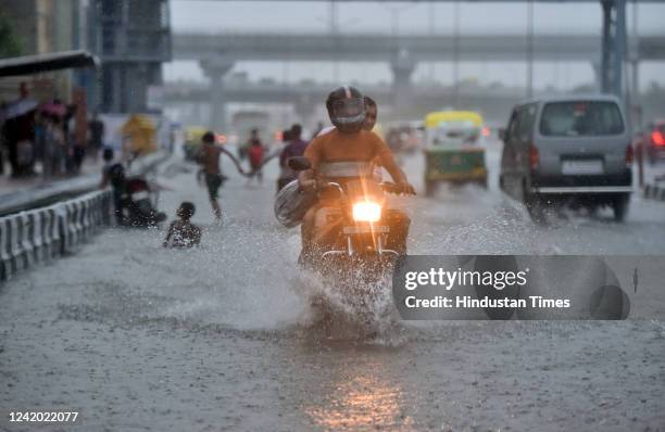 Vehicles wade through a waterlogged stretch on NH-24 during heavy rain on July 20, 2022 in New Delhi, India. The heavy downpour caused widespread...