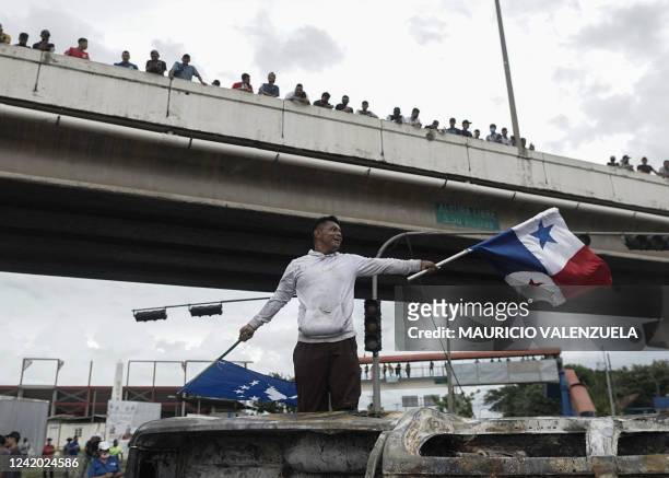 Demonstrator waves a Panamanian flag during a blockade to protest against fuel prices in Santiago, Panama, on July 20, 2022. - Fresh roadblocks went...