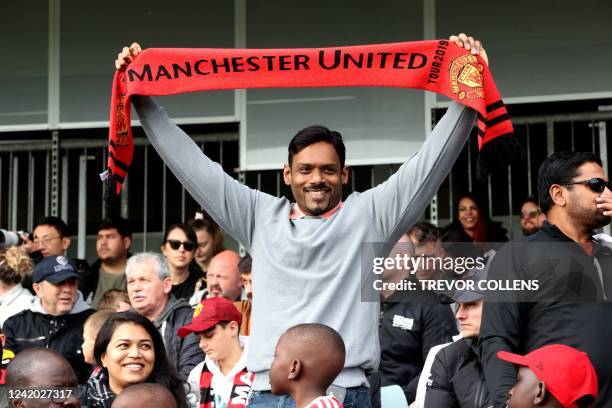 Manchester United fan waves a scarf whilst watching an open training session at the WACA stadium in Perth on July 21 ahead of the tour match between...