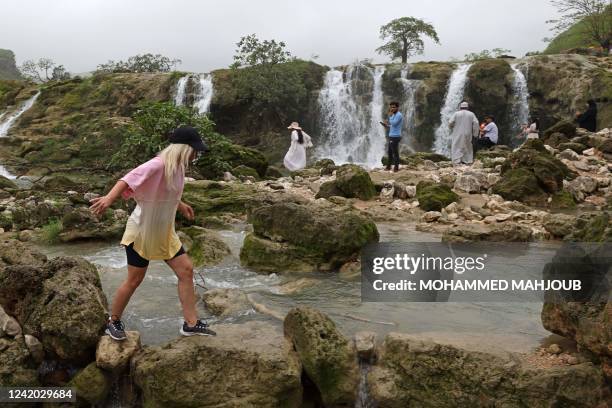 Locals and tourists tour the Wadi Darbat near Salalah, in the southern Omani province of Dhofar on July 21, 2022.