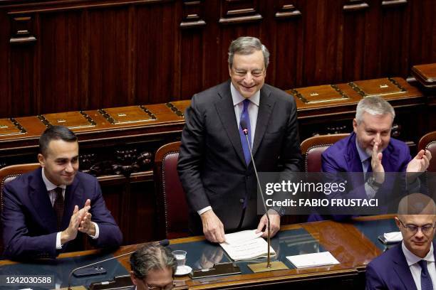 Italy's Prime Minister Mario Draghi stands as Foreign Minister Luigi Di Maio and Italian Defence Minister Lorenzo Guerini applaud upon his arrival at...