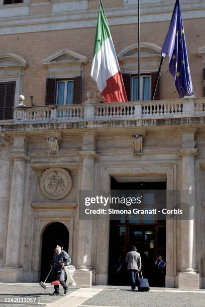 Cleaner with a broom and dustpan cleans the entrance to Montecitorio, seat of the Chamber of Deputies, on July 21, 2022 in Rome, Italy. Italian Prime...