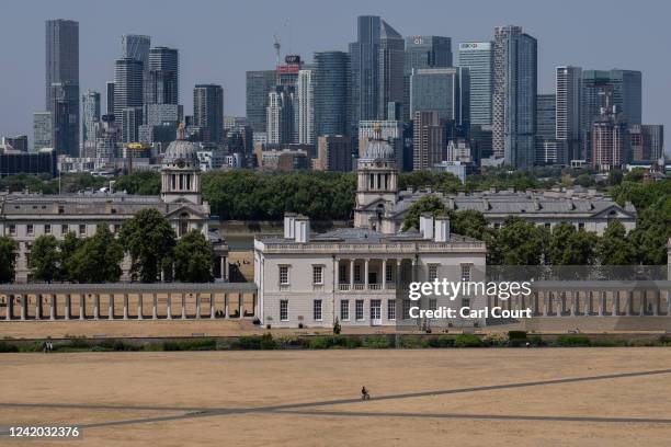 Cyclist passes dried grass in Greenwich Park on July 19, 2022 in London, England. Temperatures were expected to hit 40C in parts of the UK this week,...