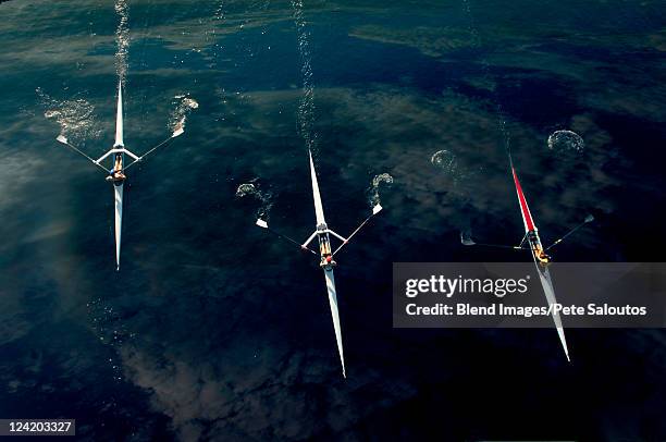 people rowing sculling boats on river - rowboat stock pictures, royalty-free photos & images