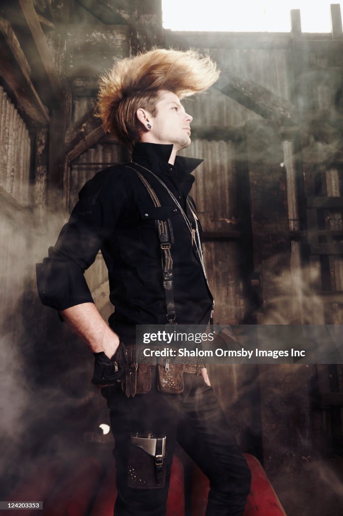Trendy Caucasian man standing in warehouse