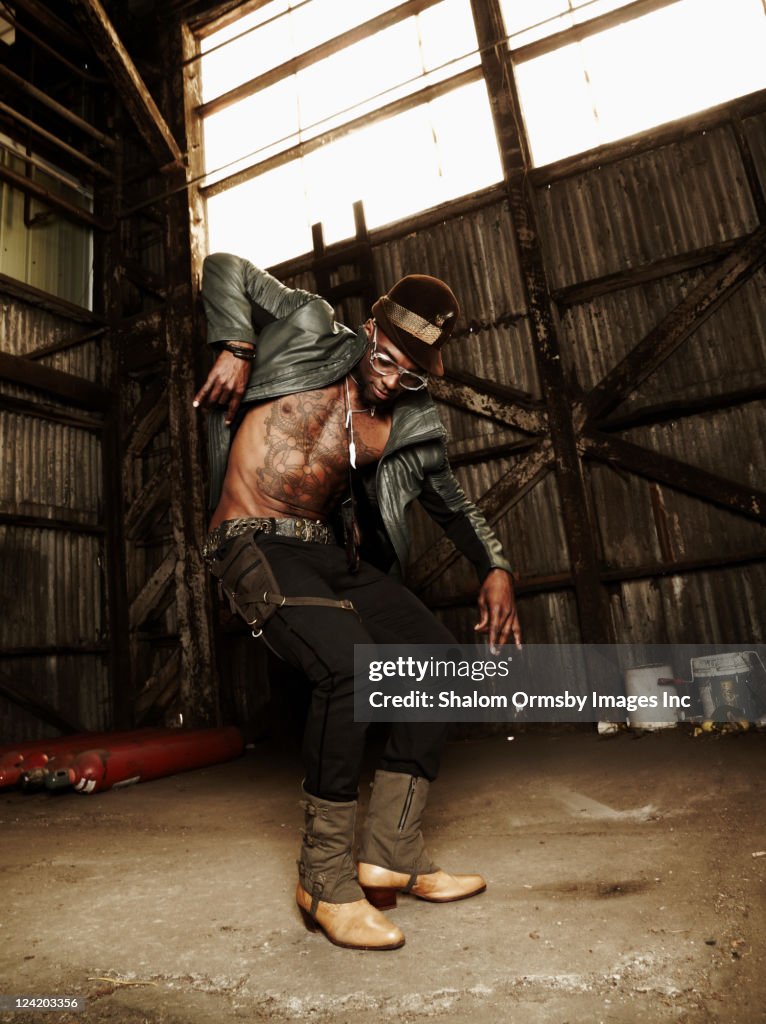 Trendy African American man dancing in warehouse